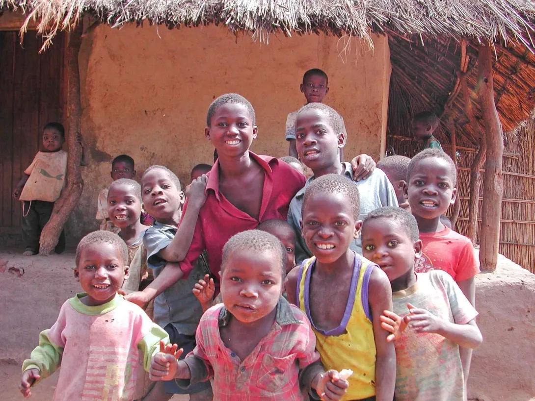 IPALA children in front of traditional dwelling
